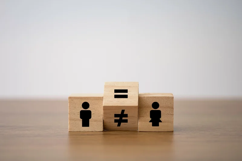 Würfel mit Symbolen Mann / Gleich / Ungleich Frau zur Darstellung des equal Payment Problems